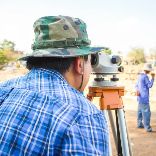 Topográfo haciendo un levantamiento topográfico en un lote